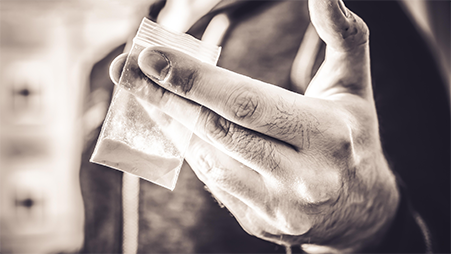 Hand holding drugs packet